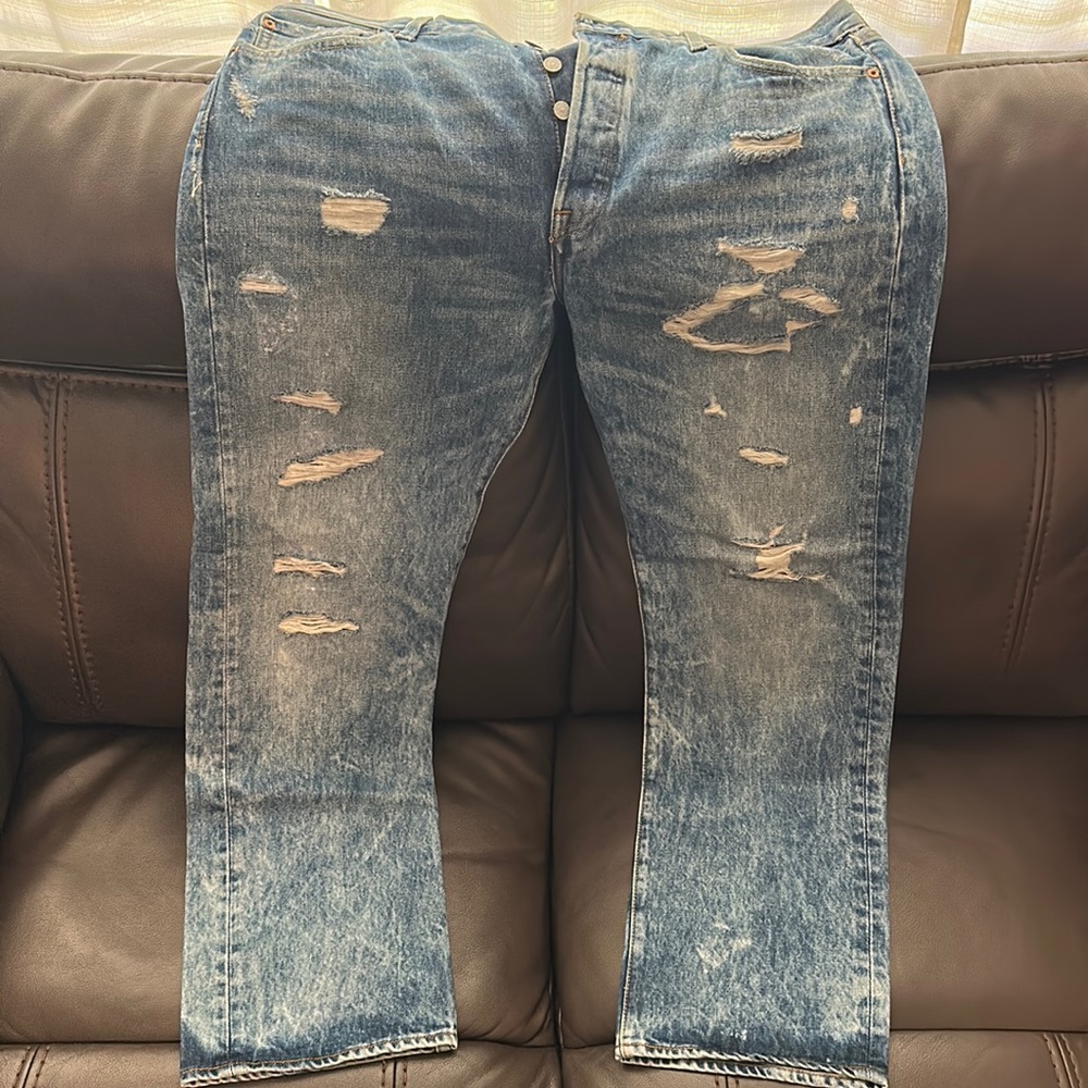 Levi’s 501 jeans size 36 x 30. Ripped and faded light blue design. Regular fit.